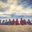 A group of young people sitting by a lake