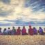 A group of young people sitting by a lake