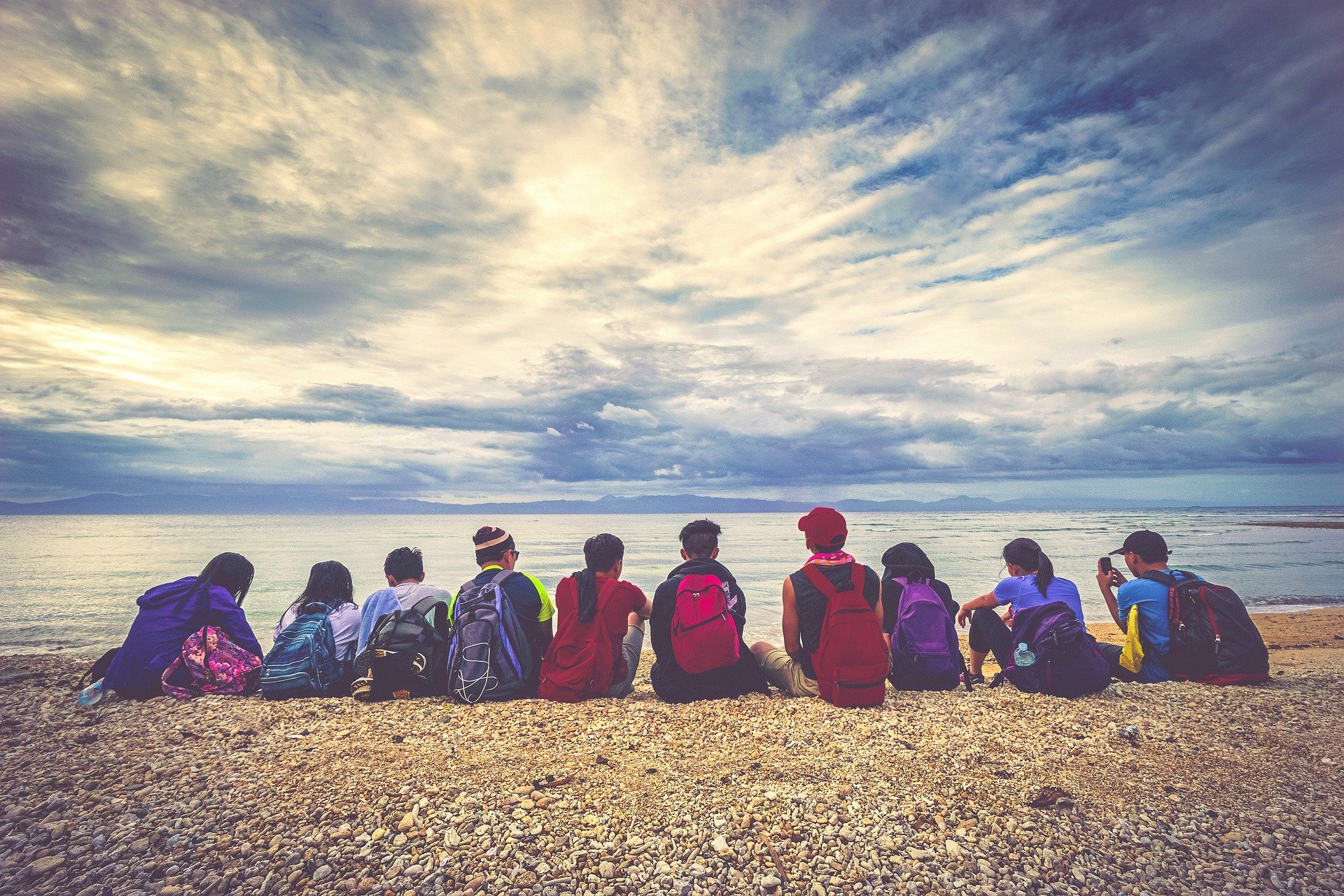 A group of young people sitting by a lake