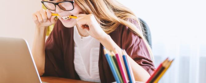 student biting pencil