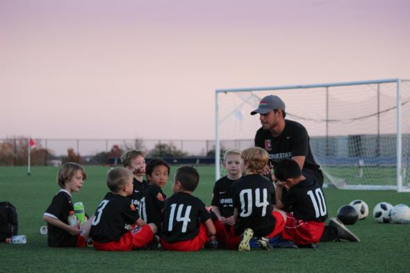 Image of children and teacher playing football