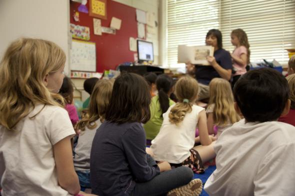 Image of primary school children learning from their teacher