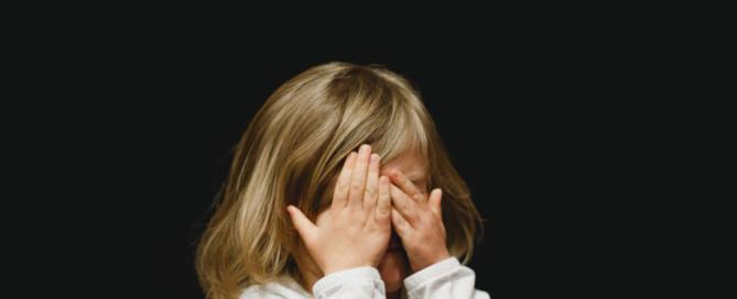 child covering face