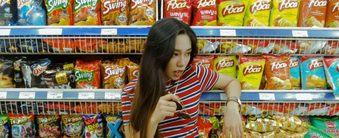 girl standing in front of food shelf