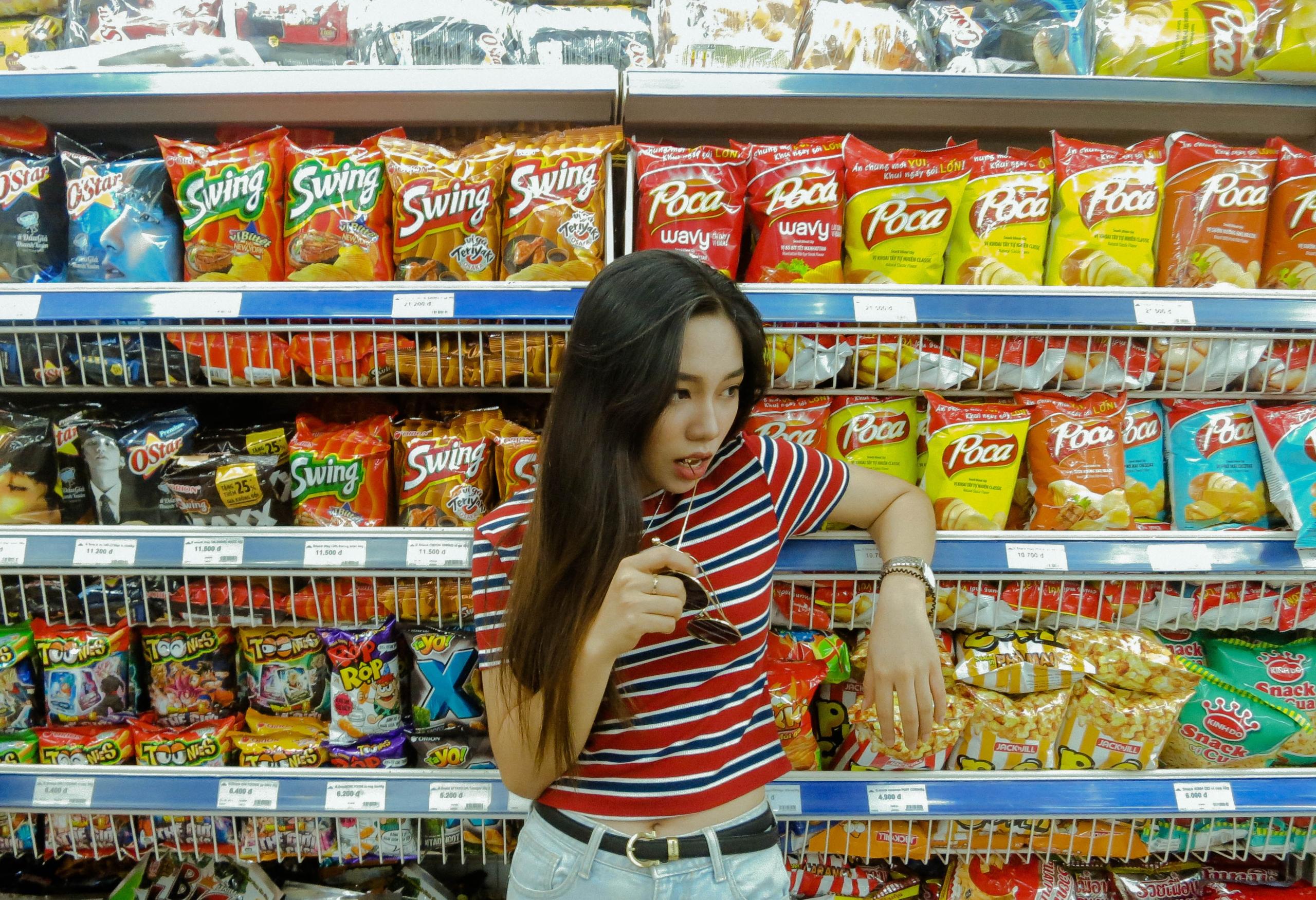 girl standing in front of food shelf