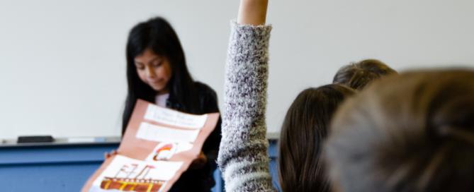 student with hand up