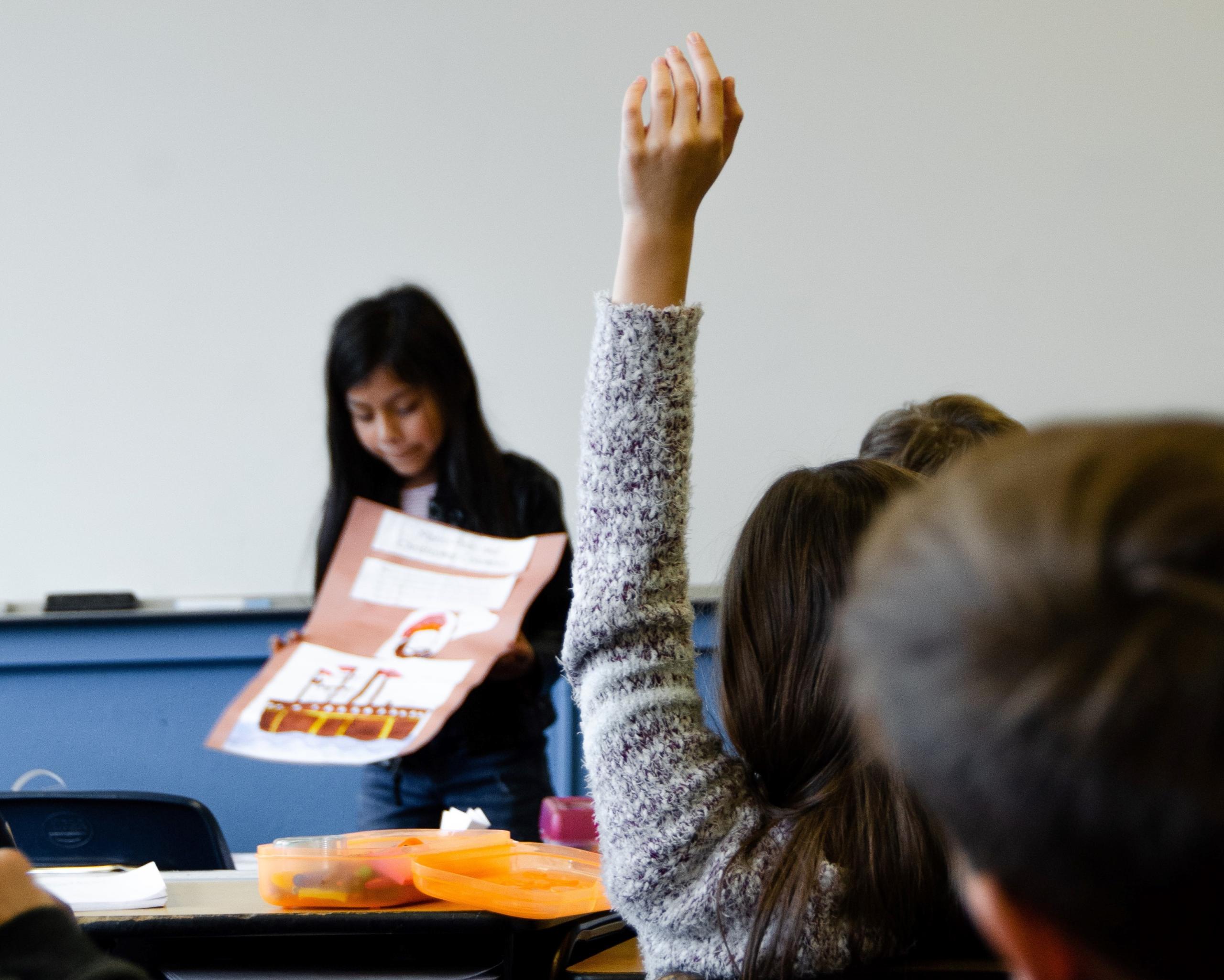 student with hand up