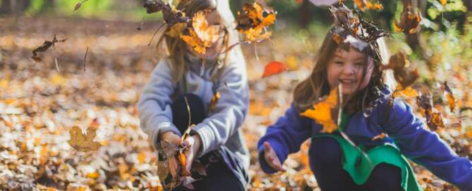 Kids outdoors in autumn leaves