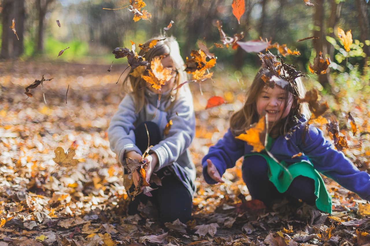 Kids outdoors in autumn leaves