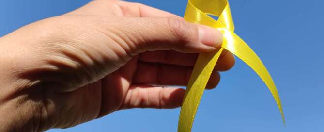Hand holding yellow ribbon