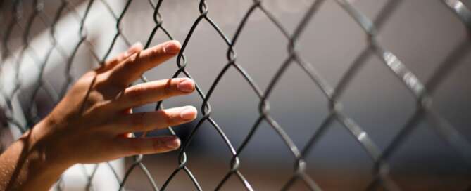 Hand on wire fence