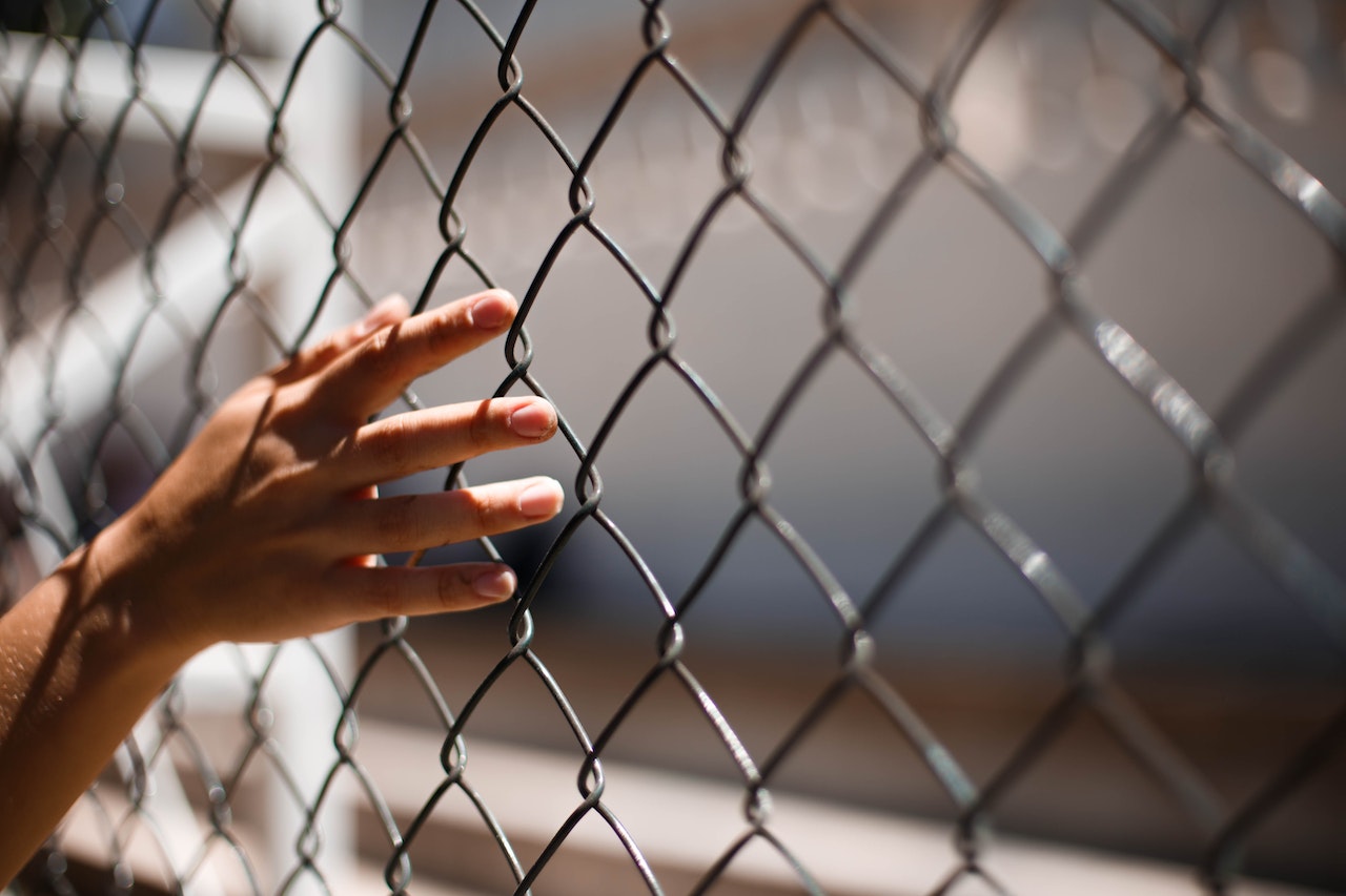 Hand on wire fence