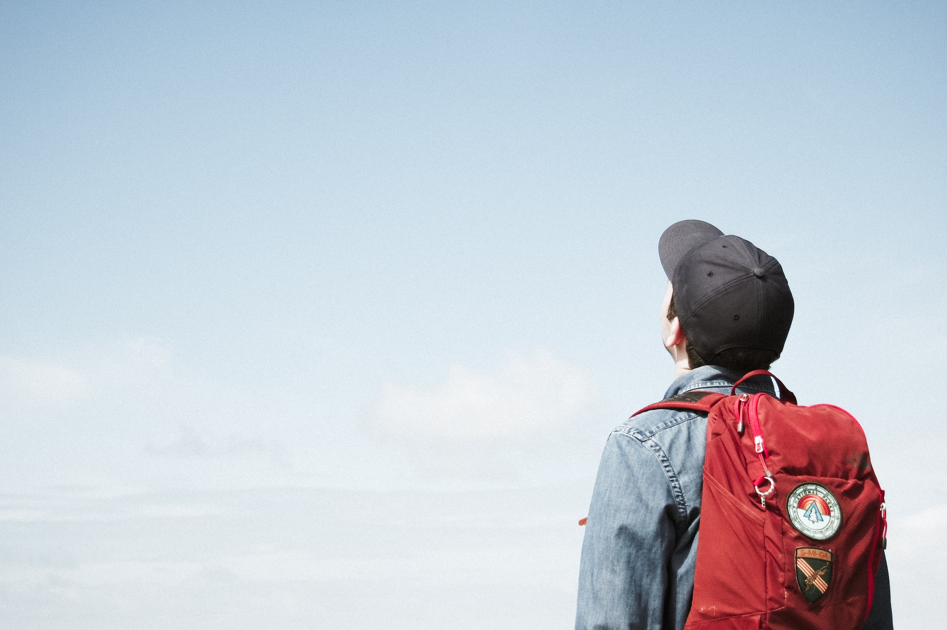 child with backpack looking to sky