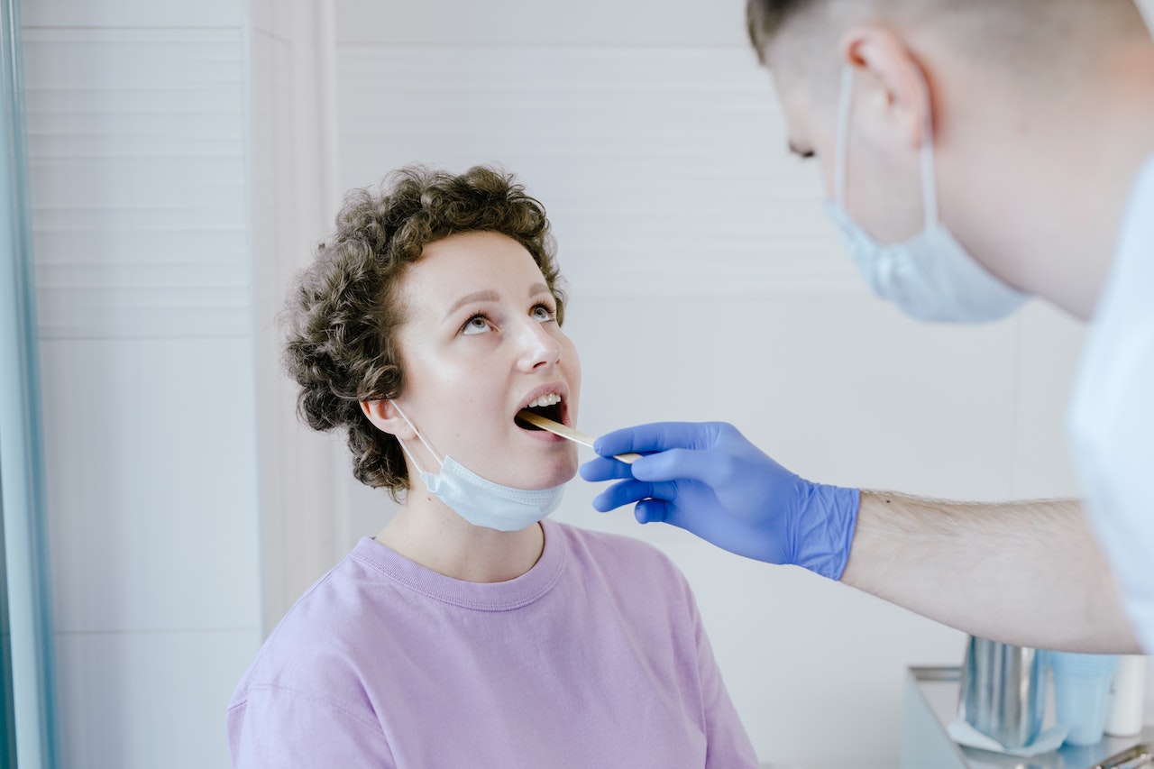 Doctor throat exam on patient