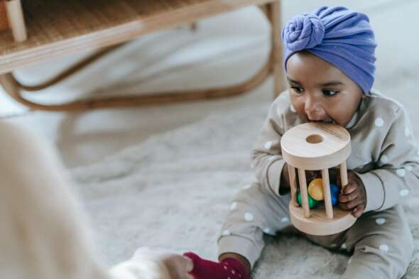 Toddler with toy in mouth
