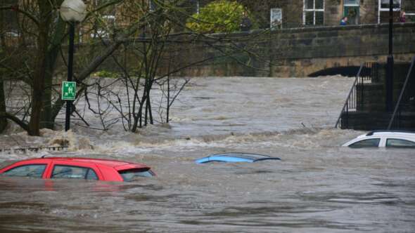 Red, blue and white cars sinking in flooding water