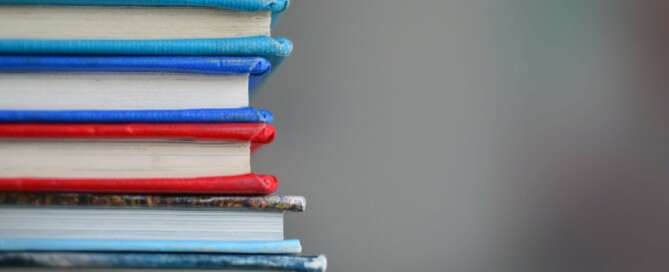 Blue, red, yellow and grey books stacked on top of each other