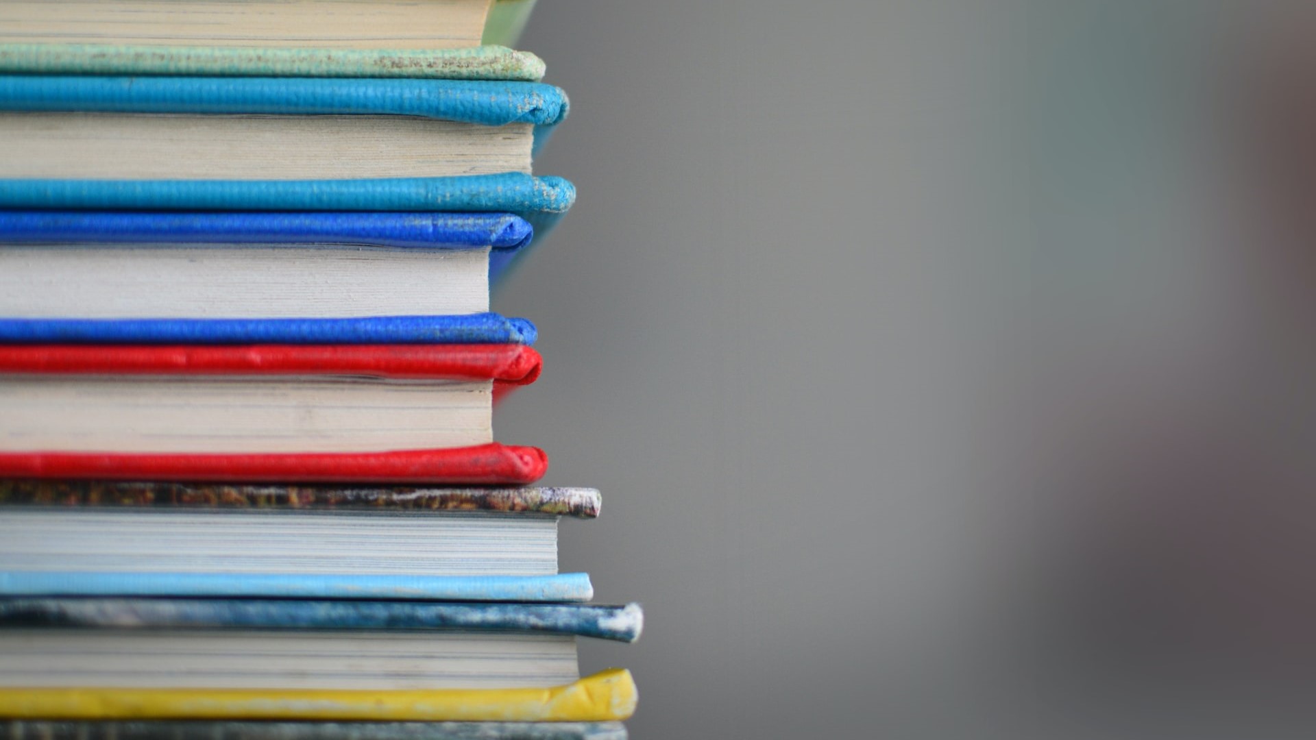 Blue, red, yellow and grey books stacked on top of each other