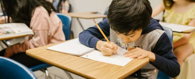 Young boy completing school work in a classroom