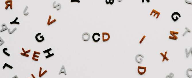 Letters scattered on white surfaced, with the letters OCD together