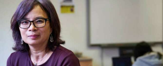 close up shot of teacher with student sitting at desk in the background