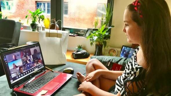 Female student on video call with fellow students remotely in class